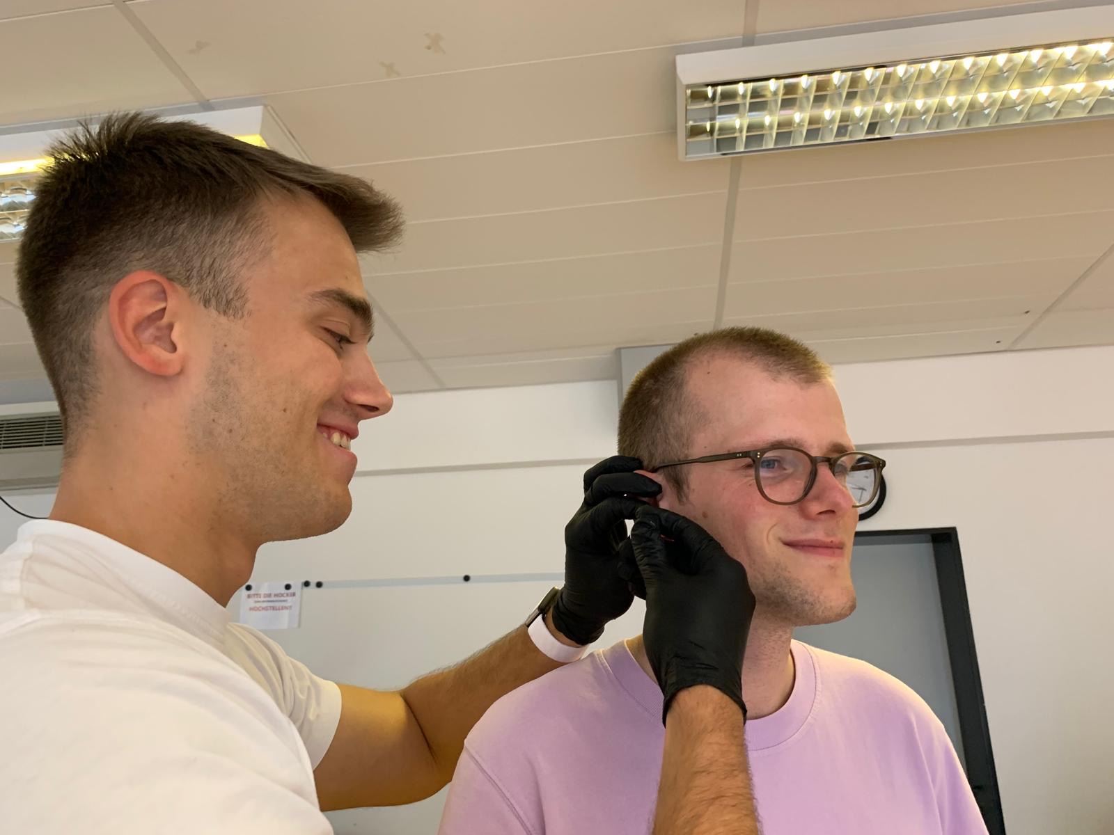 Schüler üben die Blutentnahme aus dem Ohrläppchen beim Leistungsdiagnostik-Seminar