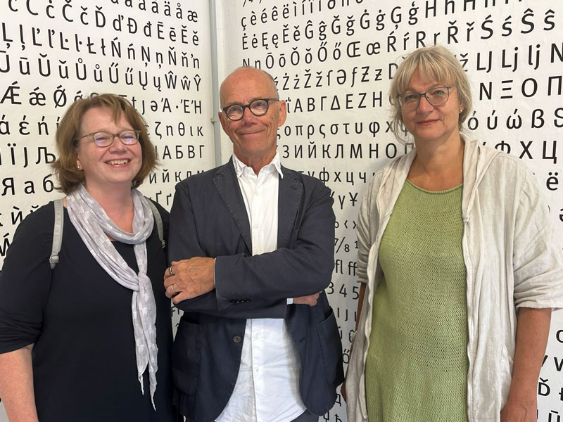 Antje Langner und Prof. Dr. Bärbel Kühne (li.) im Ausstellungsraum: Austausch über Entwurfsprozesse, Detailarbeit und die Rolle des Zufalls – zentrale Themen der Werkschau von Erik Spiekermann (m.).