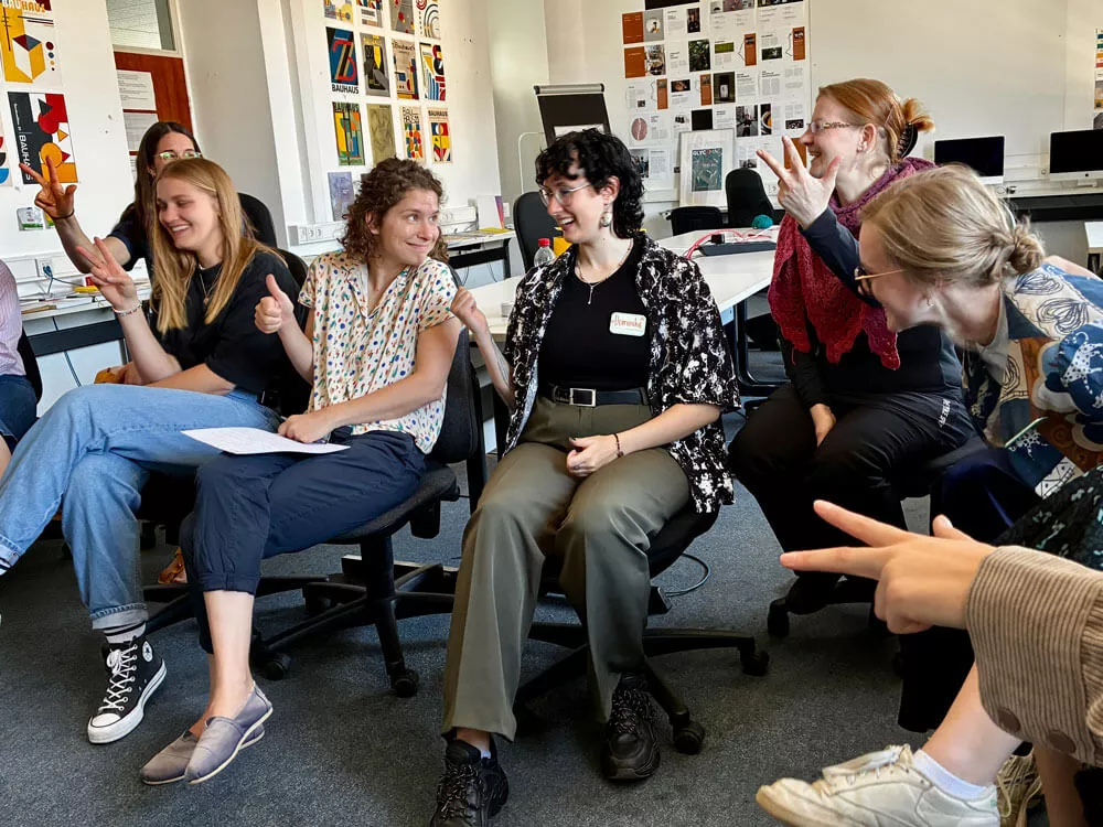 Studentinnen lachen und tauschen sich im Workshop aus.