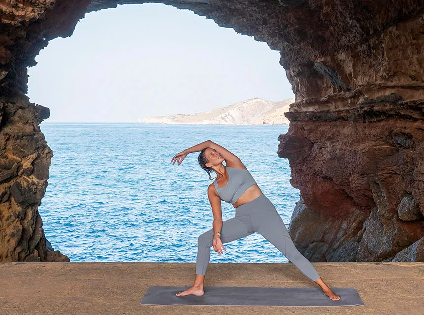 Frau macht Yoga am Meer
