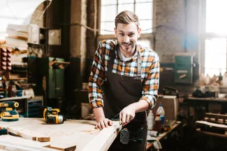 Mann an der Werkbank mit Werkzeug und hobelt