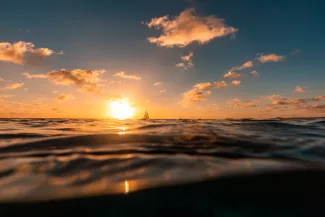 Sonnenaufgang Meer mit Boot und Wellen