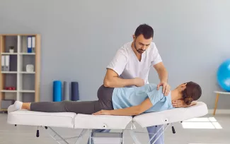Osteopath behandelt einen Patienten auf der Liege