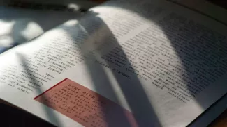 Nahaufnahme einer Magazinseite mit Schreibmaschinentext, rotem Textkasten und starkem Schattenwurf; die Seite erzeugt eine konzentrierte, nachdenkliche Atmosphäre.