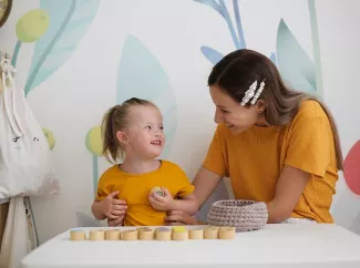 Heilpädagogin mit kleinem Mädchen mit Down-Syndrom