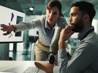Medizintechniker am Computer mit Fußprothese