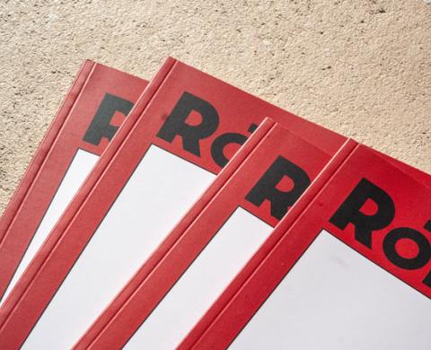 Detailaufnahme mehrerer übereinanderliegender Cover von Rote Nelken mit rotem Rand und schwarzer Typografie.