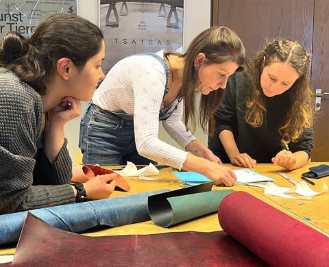 Gruppenarbeit mit drei weiblich gelesenen Personen und Ledermaterial